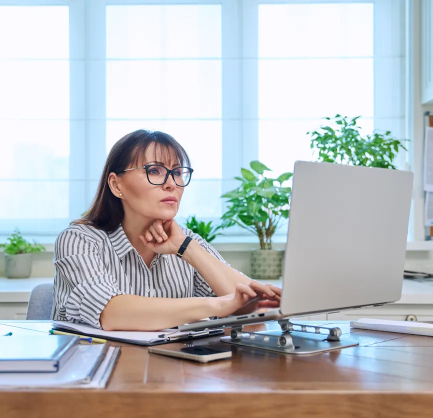 Kobieta w koszuli w paski przy laptopie — wycena apostille na podstawie skanu dokumentu